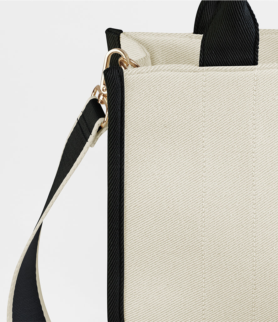 Beige handbag with black accents on a light gray background
